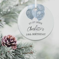 a christmas ornament hanging from a tree with a pine cone on the branch