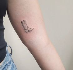 a woman's arm with a tattoo on it that has a boot in the middle