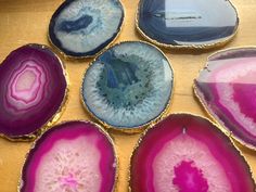 six different colored agate stones sitting on top of a wooden table