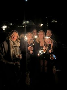 a group of people standing next to each other holding sparklers