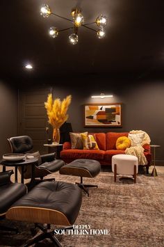 a living room filled with lots of furniture and lights above the couches in front of a painting