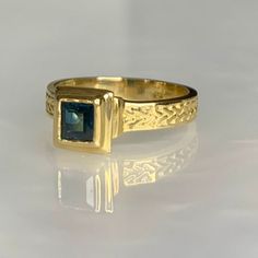 A minimalist and modern vintage 14k yellow gold solitaire ring featuring a square shaped genuine sapphire weighing 0.45 carats, sleekly set in a stylish tiered gold bezel elevating the stone above the finger with intricate detailing along its band. *Ring size: 6 1/4 *Ring weight: 3.85 Modern Sapphire Ring, Vintage Sapphire Engagement Ring, Mens Sapphire Ring, Antique Emerald Ring, Engagement Ring Sapphire, Yellow Gold Solitaire Ring, Vintage Sapphire Ring, Emerald Ring Vintage, Vintage Engagement Rings Sapphire