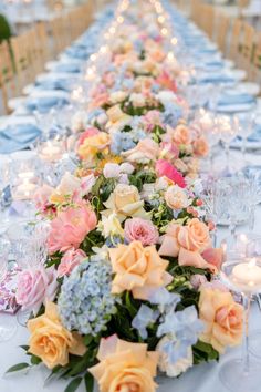 a long table with flowers and candles is set up for a formal dinner or reception