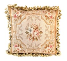 a decorative pillow with gold trimmings and flowers on the front, sitting on a white background