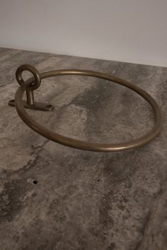 a circular metal object sitting on top of a stone counter next to a white wall