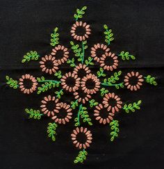 an embroidered design on a black cloth with pink and green flowers in the center,