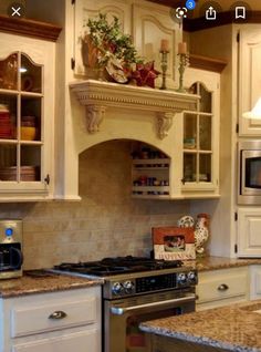 a kitchen with white cabinets and granite counter tops, an oven and microwave in the corner