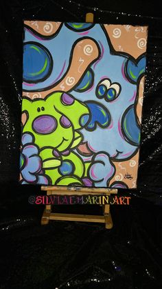 an easel with a painting on it sitting in front of a black background,