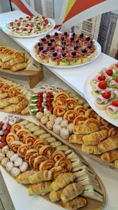 a table topped with lots of different types of food on plates and serving trays