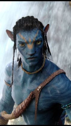 a man dressed as avatar from avatar is standing in front of a waterfall and holding a snake