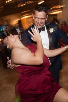 a man in a tuxedo dances with a woman in a red dress on the dance floor