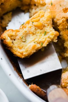 a close up of food in a pan with a spatula on the side and a knife sticking out of it