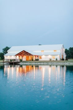 a large white barn sitting on top of a lake