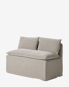 a large gray couch with two pillows on it's back and one arm extended