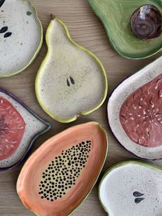 four bowls with different designs on them sitting next to each other and one has a slice of watermelon in the middle