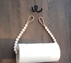 a roll of toilet paper sitting on top of a wooden floor next to a hook