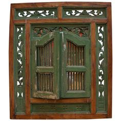 an old green wooden window with carved designs