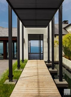 a wooden walkway leading to an open area with water and grass on both sides of the walkway