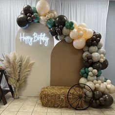 an arch made out of balloons and hay bales