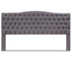 an upholstered headboard with buttons on the top and bottom, in grey fabric