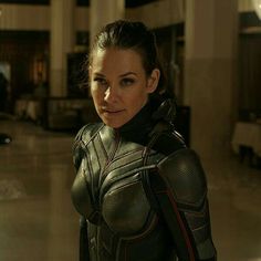 a woman dressed as ant - man stands in an empty building with her hands on her hips