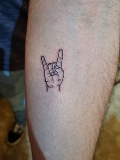 a person's arm with a tattoo on it that has the peace sign in front of them