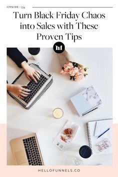 a white table topped with laptops next to flowers and other items on top of it