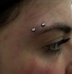 a close up of a person's nose with piercings on it