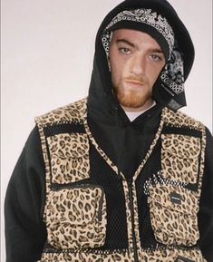 a man wearing a leopard print jacket and black hoodie