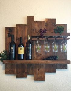 some wine glasses and bottles are sitting on a wooden shelf in front of a wall