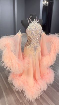 a pink dress with feathers on it