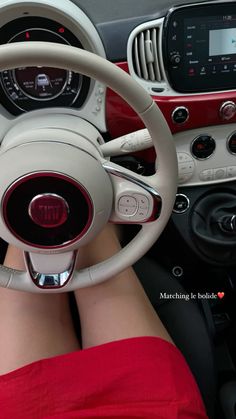 a woman is sitting in the driver's seat of a car with her feet on the steering wheel