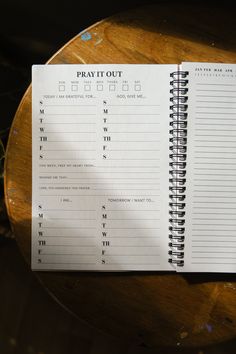 a spiral notebook sitting on top of a wooden table