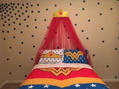 a bed with a red canopy and stars on the wall next to it is in a bedroom