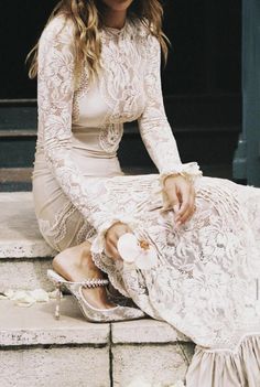 a woman is sitting on the steps in her dress