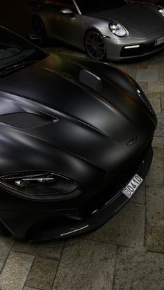 two black sports cars parked next to each other