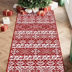 a red and white christmas rug with presents on the floor next to a small tree