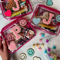 three pink plastic containers filled with cookies and candies