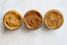 three jars filled with different types of food on top of a white countertop next to each other