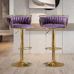 two purple and gold bar stools in front of a painting