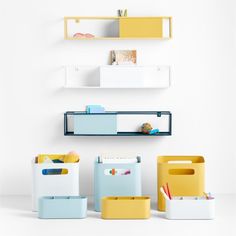 several different colored bins and shelves on the wall in a room with white walls