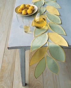 a table topped with plates and bowls filled with fruit next to a bowl of lemons