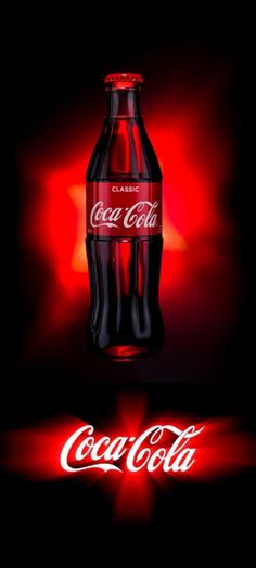 the coca cola bottle is lit up with red light and it's logo appears to be glowing