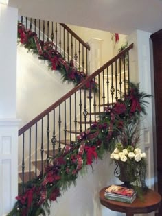 christmas garland on the banisters and stairs in a home decorated with poinsettia