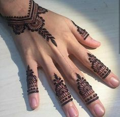 a woman's hand with henna tattoos on it