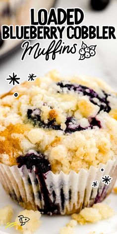 a close up of a muffin on a plate with blueberries and crumbs