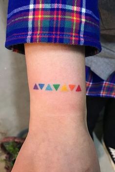 a woman's arm with colorful tattoos on her left wrist and the word love written in