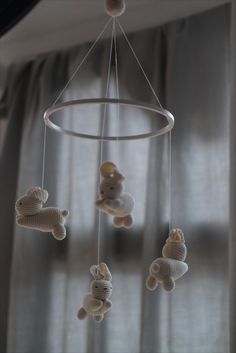 a baby crib mobile with teddy bears hanging from it's sides in front of a window