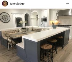 a large kitchen island with stools in the middle and an oven on the other side