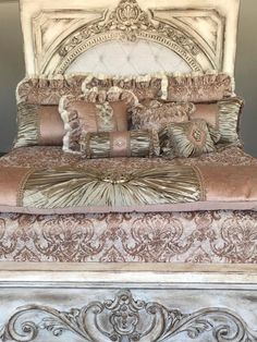 an ornate bed with many pillows on it